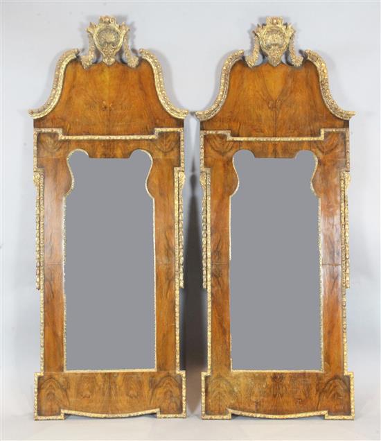 A pair of early 18th century style parcel gilt walnut wall mirrors, W.2ft 4in. H.5ft 10in.